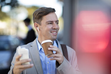 Businessman with cell phone listening to music - ZEF10477