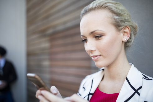 Frau schaut auf ihr Mobiltelefon - ZEF10487