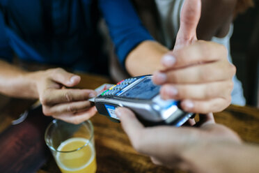 Nahaufnahme eines mit Kreditkarte zahlenden Mannes in einem Restaurant - KIJF00849