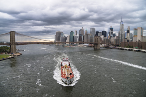 USA, New York City, Schiff auf dem East River und Skyline von Manhattan, lizenzfreies Stockfoto