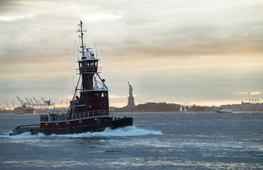 USA, New York City, tugboat on Upper New York Bay with Statue of Liberty in background - STCF00261
