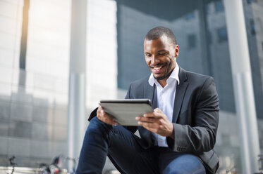 Smiling businessman using tablet - DIGF01340