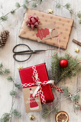 Christmas decoration, scissors and wrapped presents on wood - SARF02949