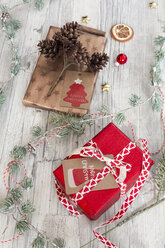 Weihnachtsdekoration und eingepackte Geschenke auf Holz - SARF02958