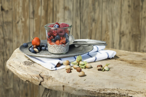 Gläser mit Chia-Pudding mit verschiedenen Beeren, Granatapfelkernen und Haselnüssen - ASF06024