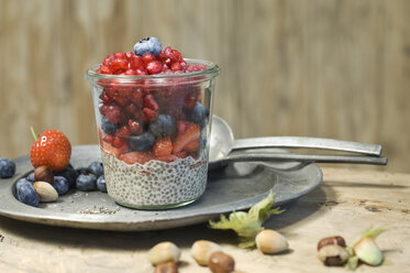 Gläser mit Chia-Pudding mit verschiedenen Beeren, Granatapfelkernen und Haselnüssen - ASF06025