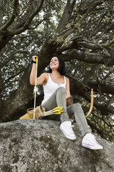 Happy archeress sitting on a rock - ABZF01341