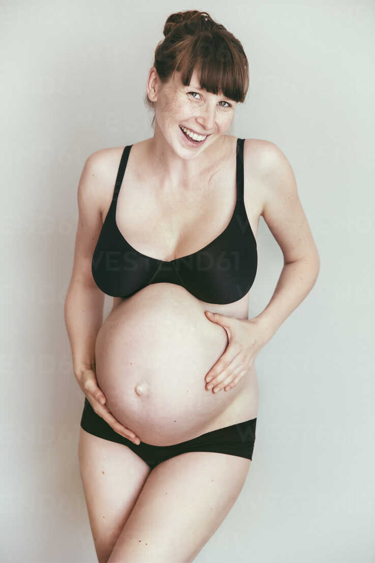 Happy expectant mother in underwear stock photo