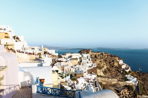 Griechenland, Santorini, Oia, Blick auf das Dorf in der Abenddämmerung mit Touristen, die auf den Sonnenuntergang warten, lizenzfreies Stockfoto