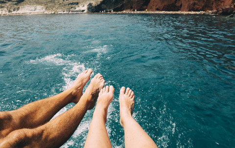 Griechenland, Santorini, Beine eines Paares vor dem Meer, lizenzfreies Stockfoto