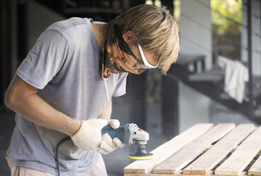 Man sanding wood with a random orbital sander - KNTF00519