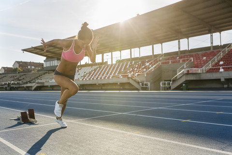 Weibliche Athletin läuft auf der Rennstrecke, lizenzfreies Stockfoto