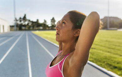 Portrait of athlete stretching in stadium - MGOF02481