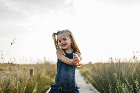 Happy little girl standing on boardwalk in nature stock photo