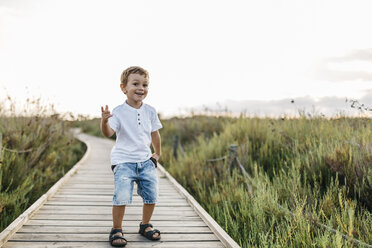 Glücklicher kleiner Junge auf der Strandpromenade in der Natur - JRFF00869