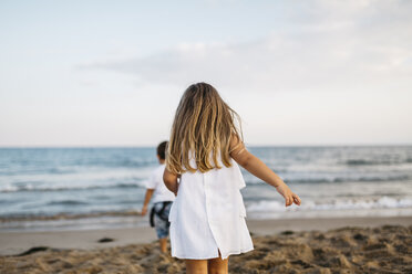 Rückansicht eines kleinen Mädchens, das mit seiner Freundin am Strand spielt - JRFF00879