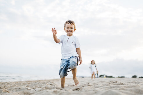 Glücklicher kleiner Junge spielt am Strand - JRFF00888