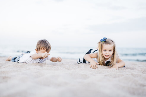 Little boy and little girl playing on the beach - JRFF00898