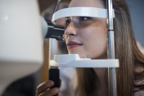 Junge Frau bei einem Sehtest beim Optometristen - ZEF10544