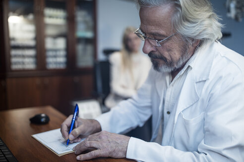 Augenarzt schreibt Krankenakte eines Patienten - ZEF10559