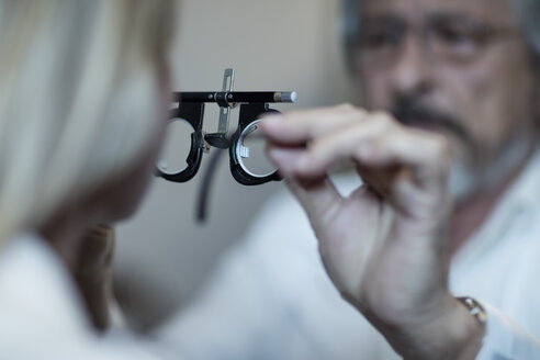 Optometrist adjusting test frame for patient - ZEF10566