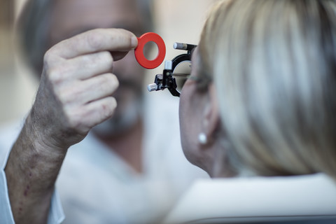 Optometristin beim Einstellen der Testfassung für den Patienten, lizenzfreies Stockfoto