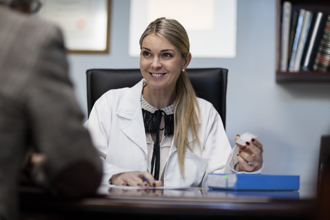 Optometristin im Gespräch mit einem Patienten, lizenzfreies Stockfoto