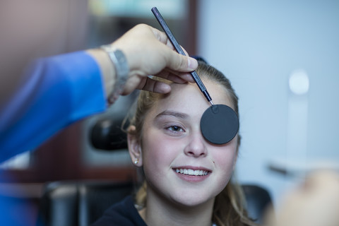 Mädchen beim Sehtest beim Optiker, lizenzfreies Stockfoto