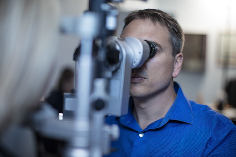 Optometrist macht Augentest mit Patient, lizenzfreies Stockfoto