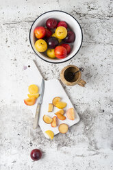 Various plums in bowl, chopping board with knife - MYF01790