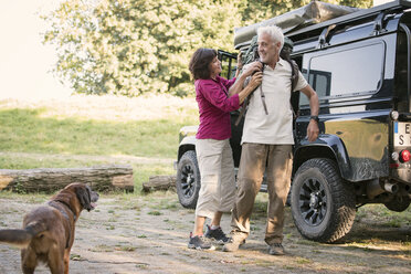 Senior couple next to cross country vehicle preparing for a hike - ONF01019