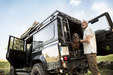 Älterer Mann mit Hund am Geländewagen - ONF01058