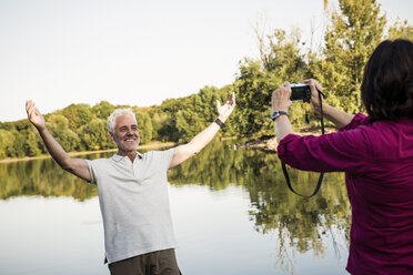 Glückliches Seniorenpaar an einem See beim Fotografieren - ONF01067