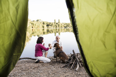 Senior couple camping with dog at a lake - ONF01079