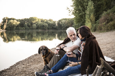 Senior couple with dog at a lake in the evening - ONF01080