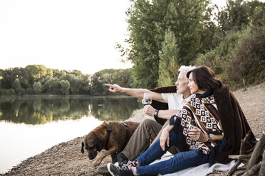 Senior couple with dog at a lake in the evening - ONF01081