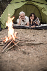 Glückliches älteres Paar liegt im Zelt am Lagerfeuer - ONF01101