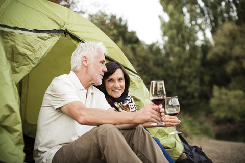 Älteres Paar sitzt mit Wein in einem Zelt, lizenzfreies Stockfoto