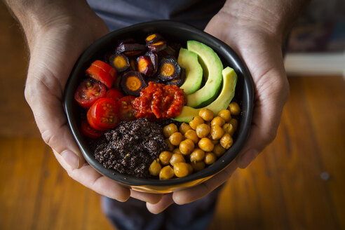 Männerhände halten Buddha-Schale mit Amaranth, Avocado, Purple Haze, gerösteten Kichererbsen, Tomaten, Ajvar - LVF05388