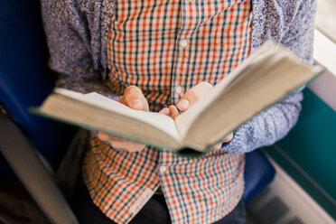 Young man reading book, partial view - FMOF00138