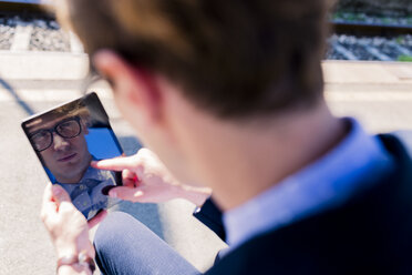 Junger Mann macht Selfie mit Mini-Tablet - FMOF00146