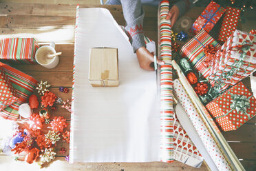 Woman cutting wrapping paper for Christmas gifts - RTBF00425
