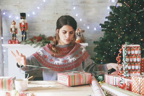 Frau wickelt Weihnachtsgeschenke ein, lizenzfreies Stockfoto