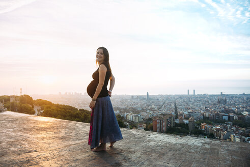 Spanien, Barcelona, Schwangere Frau genießt den Blick über die Stadt - GEMF01131