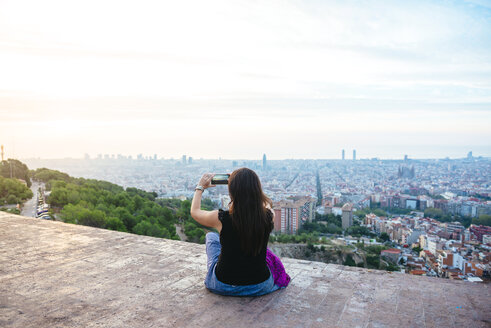 Spain, Barcelona, Woman taking picture of thhe city with her smart phone - GEMF01133