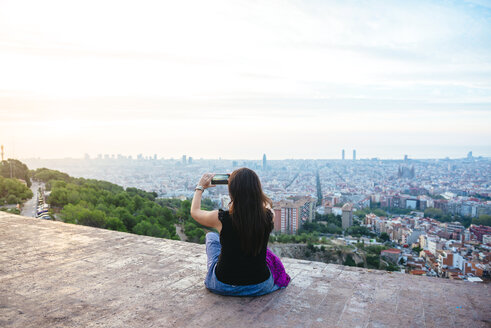 Spanien, Barcelona, Frau fotografiert die Stadt mit ihrem Smartphone - GEMF01133