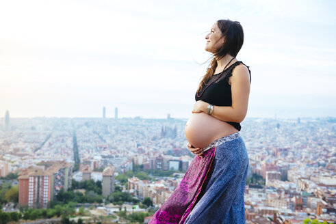 Spanien, Barcelona, Schwangere Frau genießt den Blick über die Stadt - GEMF01134