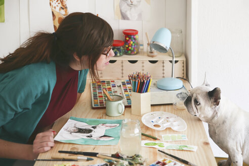 Künstlerin beobachtet französische Bulldogge in ihrem Atelier - RTBF00447