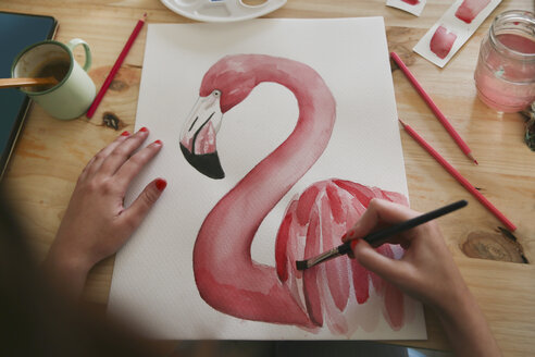 Von Frauenhand gemaltes Aquarell eines Flamingos auf dem Schreibtisch in ihrem Atelier - RTBF00452