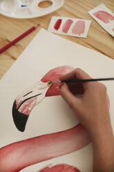 Von Frauenhand gemaltes Aquarell eines Flamingos auf dem Schreibtisch in ihrem Atelier - RTBF00453